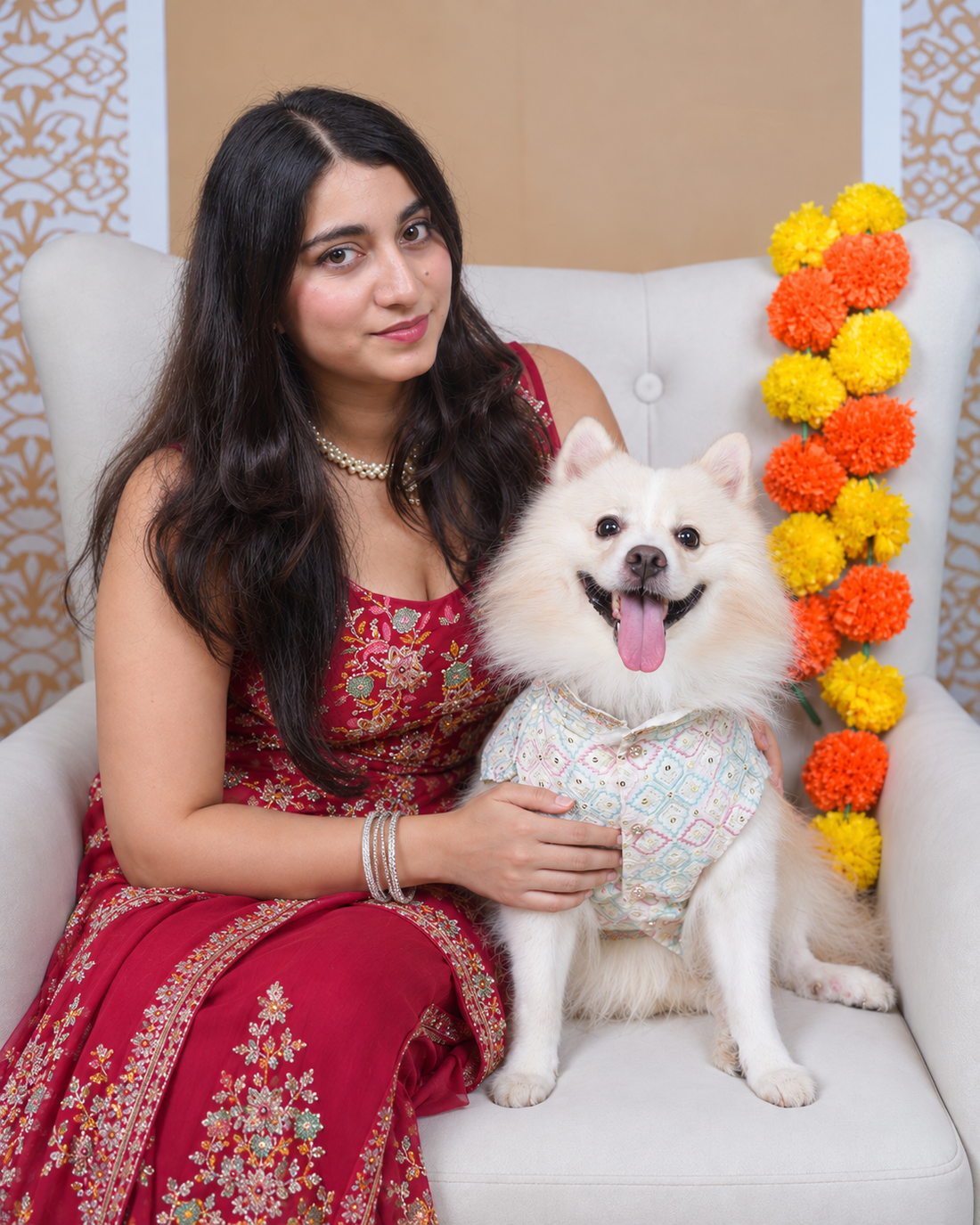 Woman in a red outfit with an Indian Spitz wearing the Mishri Sheesha dog kurta